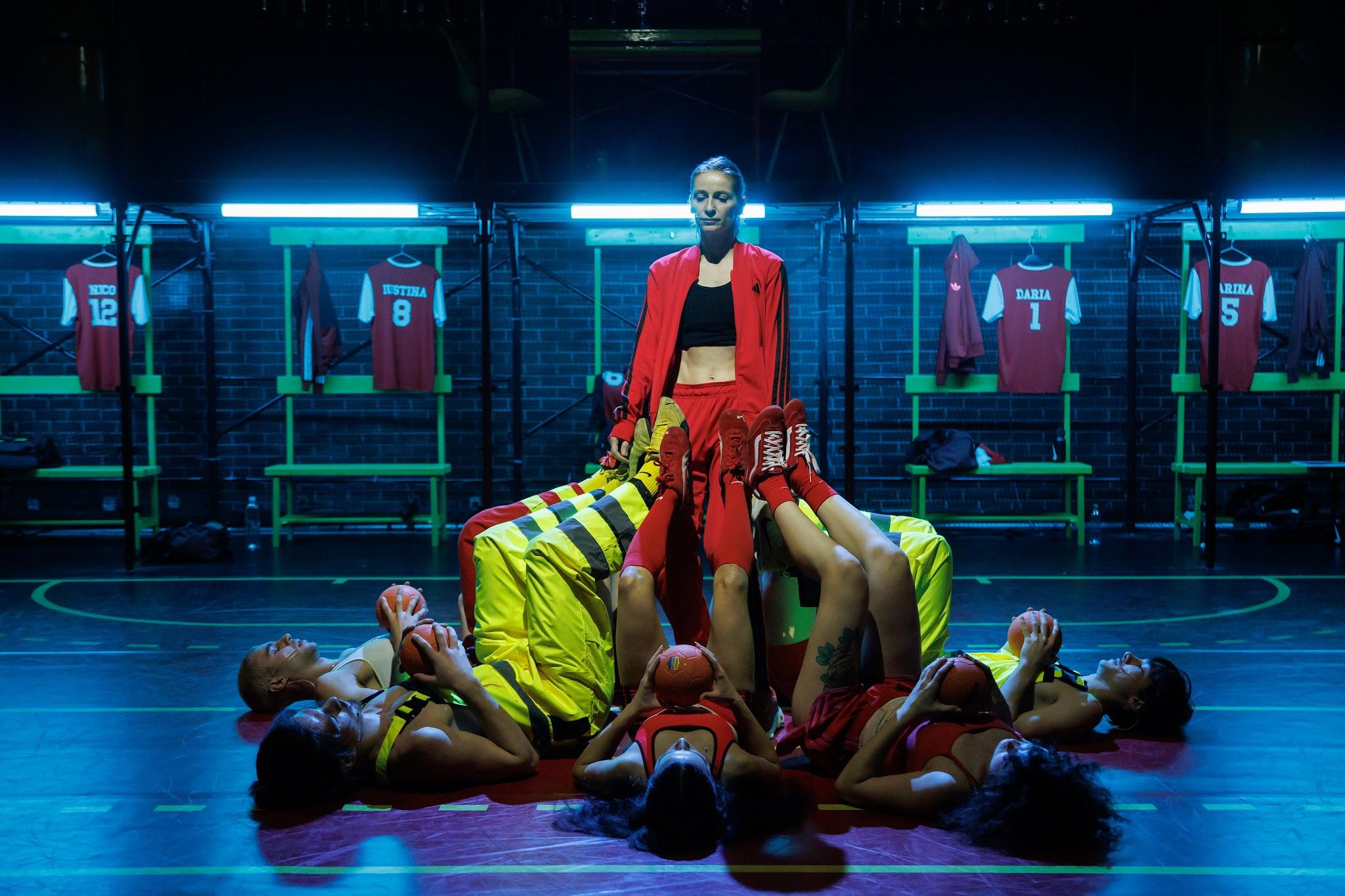 The handball team in a choreographed tableau on a blue-lit stage